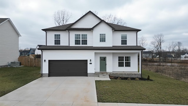 view of front of home featuring central AC, a garage, and a front yard