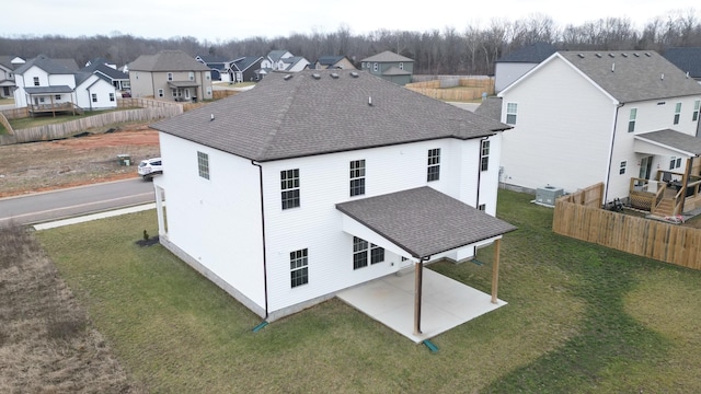 rear view of house with a lawn, a patio area, and central air condition unit