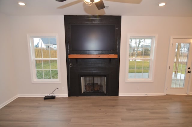 unfurnished living room with a fireplace, hardwood / wood-style floors, and a wealth of natural light