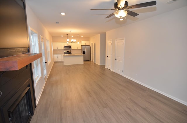 unfurnished living room featuring light hardwood / wood-style flooring and ceiling fan