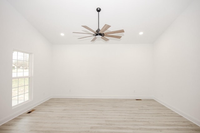 empty room with ceiling fan and light hardwood / wood-style floors