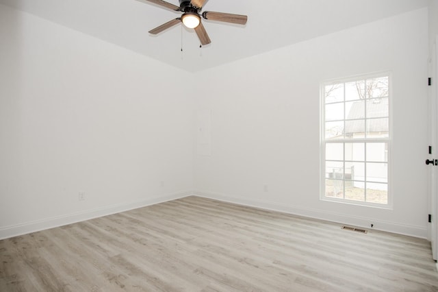 empty room with ceiling fan, a healthy amount of sunlight, and light wood-type flooring