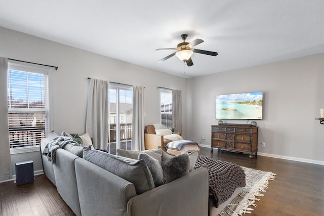 living room with dark wood-type flooring and ceiling fan