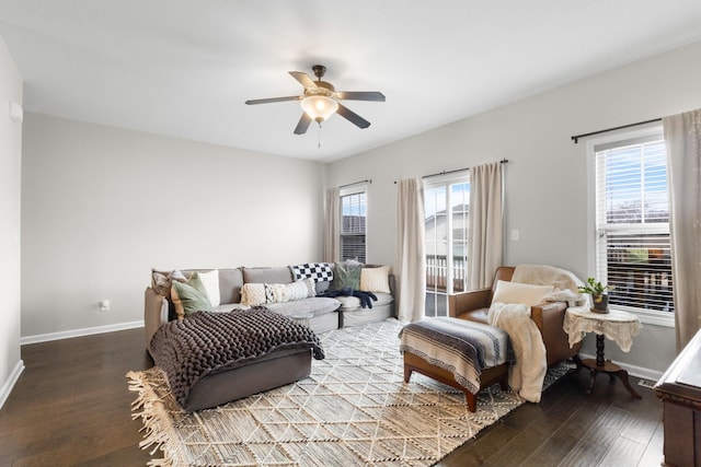 living room featuring dark wood-type flooring and ceiling fan