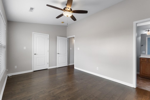 unfurnished bedroom featuring dark hardwood / wood-style flooring, lofted ceiling, ceiling fan, and ensuite bathroom