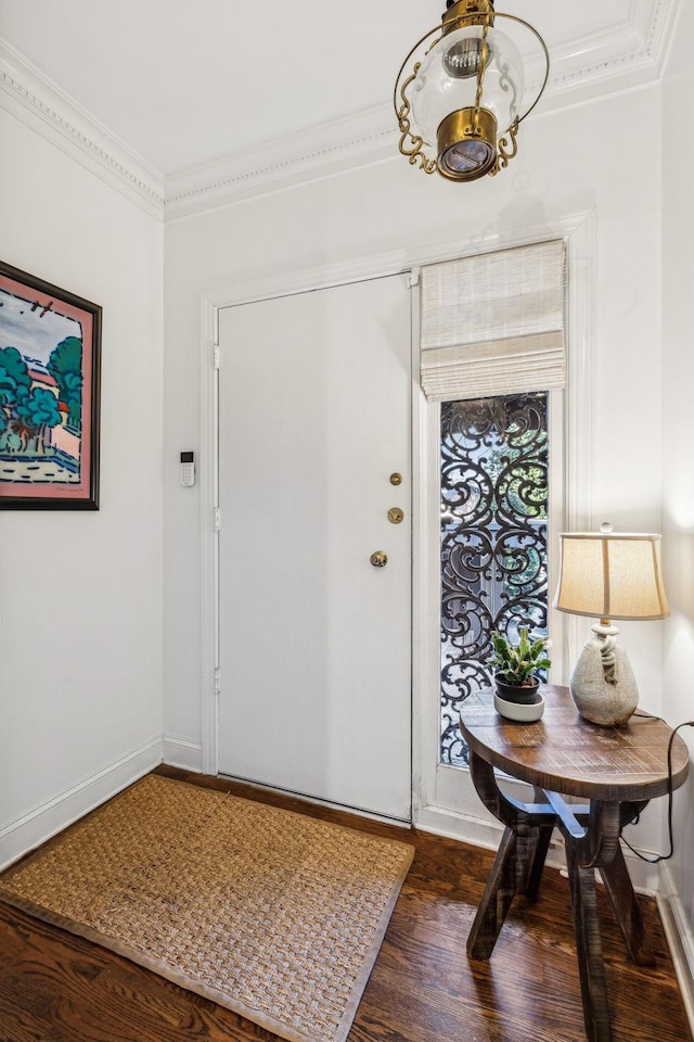 foyer entrance with crown molding, dark wood-type flooring, and a notable chandelier