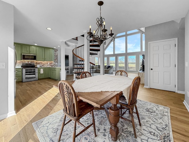 dining room featuring a notable chandelier, recessed lighting, stairway, light wood-style floors, and baseboards