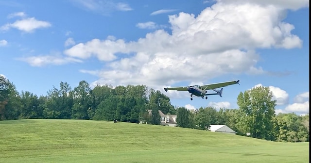 view of home's community featuring a lawn and golf course view