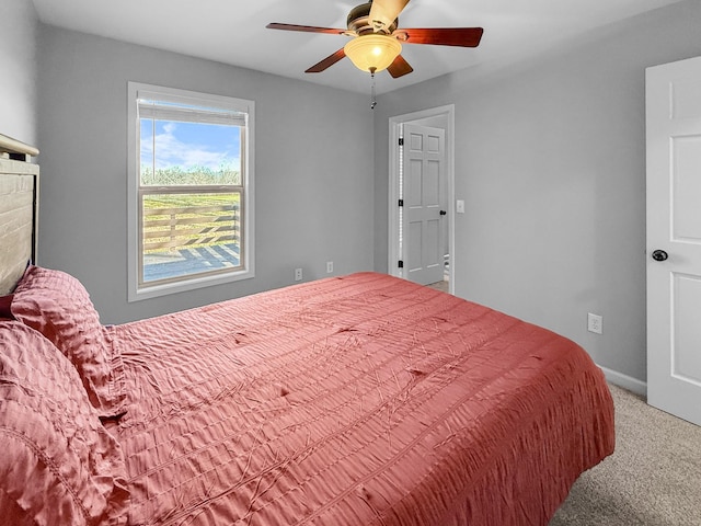 carpeted bedroom with ceiling fan and baseboards