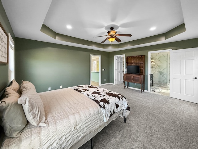 bedroom with carpet, a raised ceiling, connected bathroom, ceiling fan, and baseboards