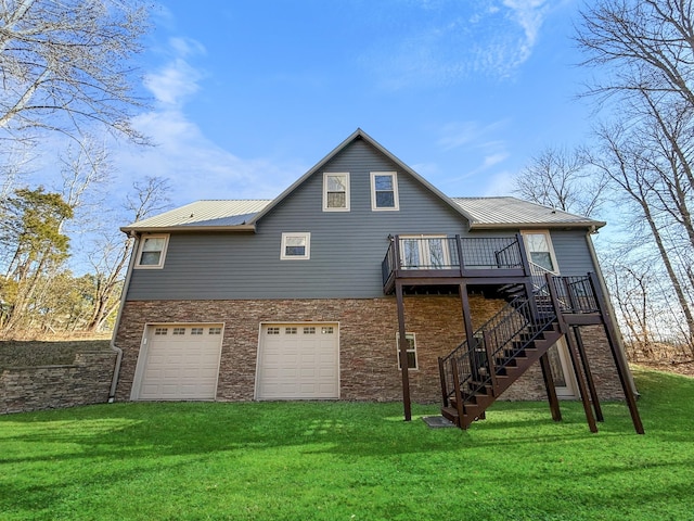 back of house featuring a lawn, an attached garage, metal roof, a deck, and stairs