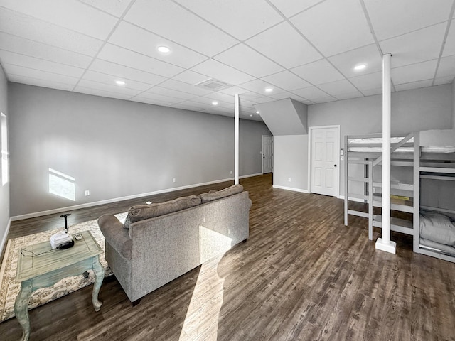 living area with dark wood finished floors, recessed lighting, visible vents, a drop ceiling, and baseboards