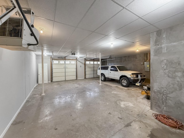 garage with a heating unit, electric panel, and baseboards