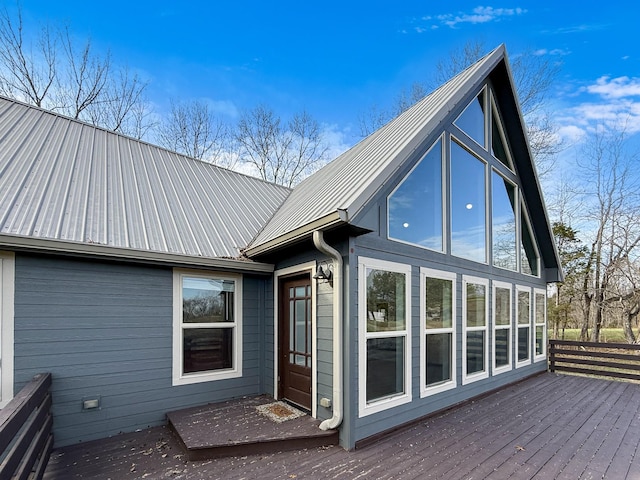 back of property with metal roof and a wooden deck