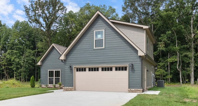 view of front of home featuring central AC unit, a garage, and a front lawn