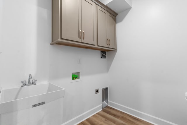 laundry area featuring sink, cabinets, light hardwood / wood-style floors, hookup for a washing machine, and hookup for an electric dryer