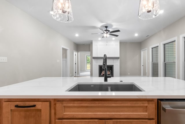 kitchen featuring pendant lighting, ceiling fan, dishwasher, and sink