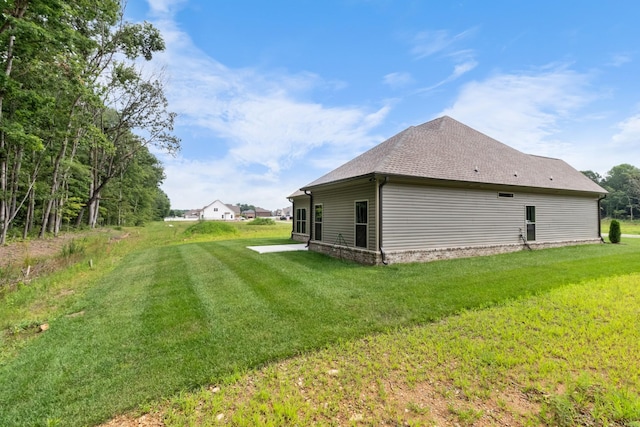 view of property exterior with a patio area and a lawn