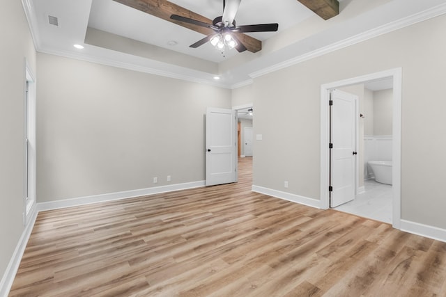 unfurnished bedroom with crown molding, ensuite bathroom, a tray ceiling, and light hardwood / wood-style floors