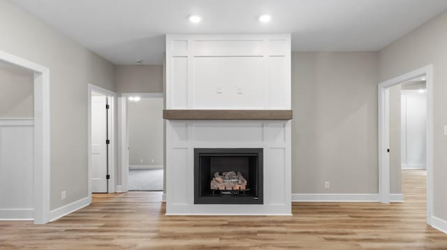 unfurnished living room with light hardwood / wood-style floors and a large fireplace