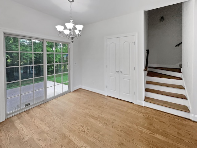3047 Dogwood Trl, Spring Hill, TN 37174 - unfurnished dining area featuring a chandelier, wood finished floors, stairs, and baseboards