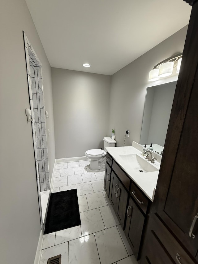 bathroom with walk in shower, vanity, and toilet