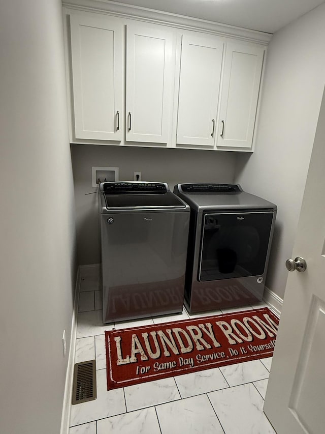 washroom featuring cabinets and separate washer and dryer