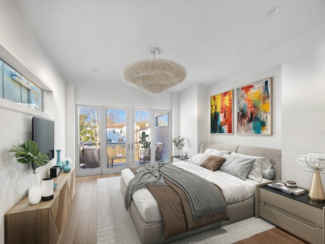 bedroom with wood-type flooring and access to outside