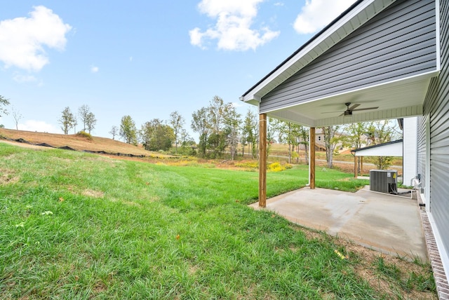 view of yard featuring central AC, ceiling fan, a patio area, and a rural view