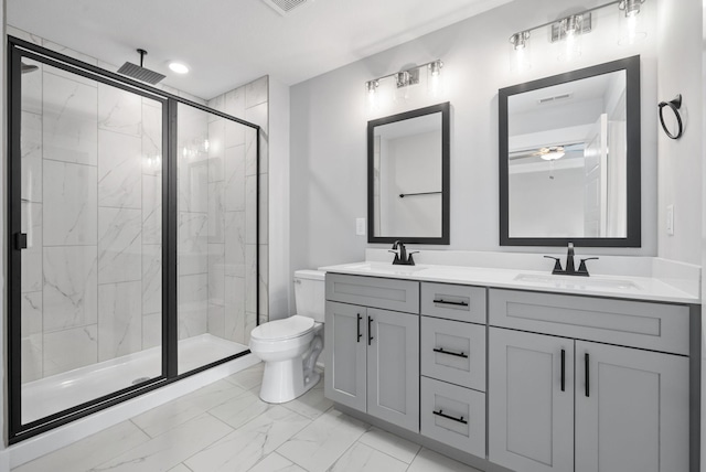 bathroom featuring vanity, toilet, and a shower with shower door