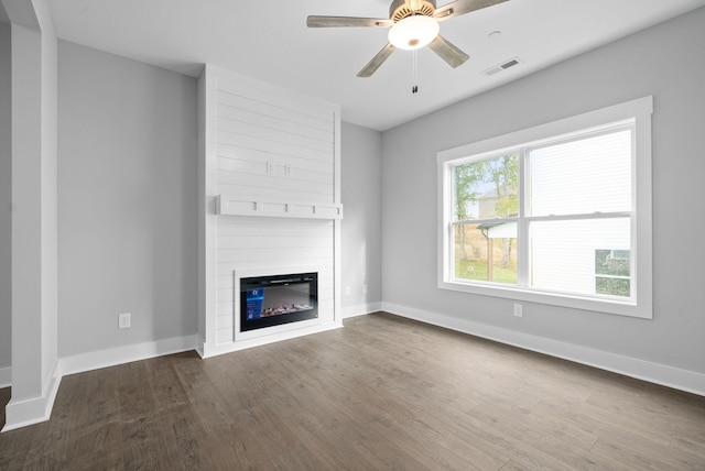 unfurnished living room featuring ceiling fan, a fireplace, and dark hardwood / wood-style flooring