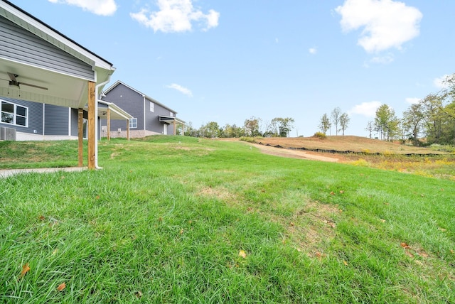 view of yard with a rural view and ceiling fan