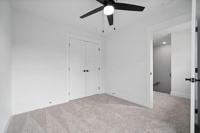 unfurnished bedroom featuring carpet, ceiling fan, and a closet