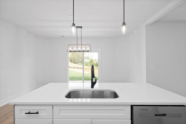 kitchen with dishwasher, sink, white cabinets, hanging light fixtures, and light hardwood / wood-style floors