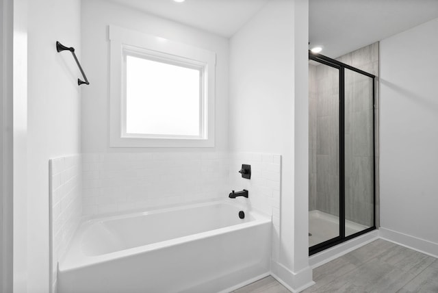 bathroom with hardwood / wood-style flooring and shower with separate bathtub