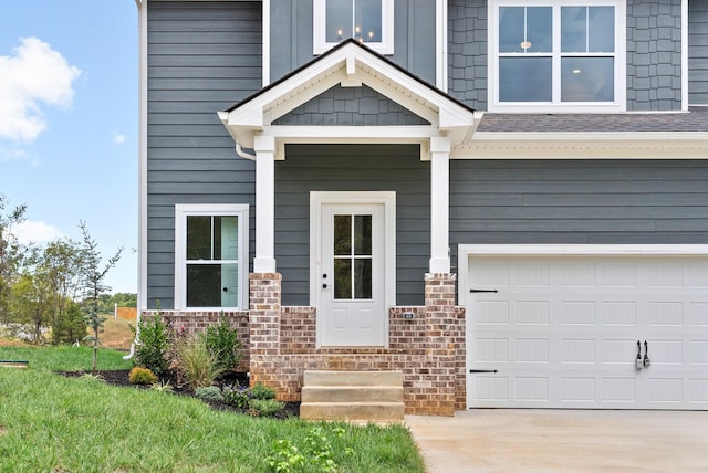 entrance to property featuring a garage and a lawn