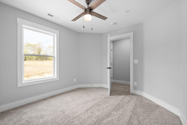 empty room with ceiling fan and carpet flooring