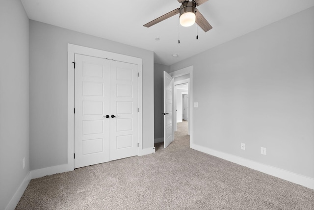 unfurnished bedroom with light carpet, a closet, and ceiling fan