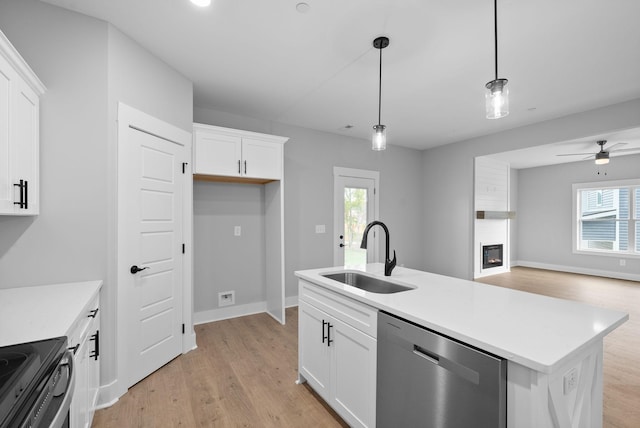 kitchen with pendant lighting, sink, a kitchen island with sink, white cabinets, and stainless steel dishwasher