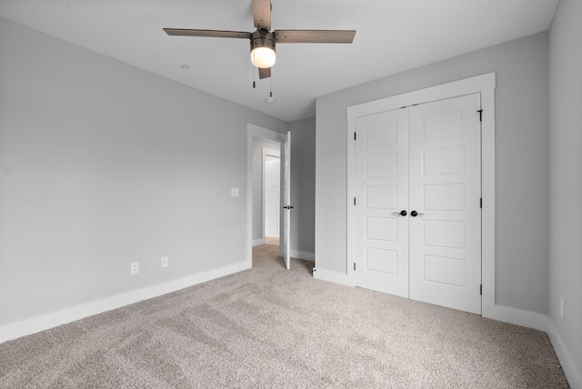 unfurnished bedroom featuring ceiling fan, light colored carpet, and a closet