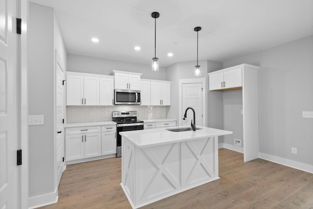 kitchen with sink, stainless steel appliances, hanging light fixtures, and white cabinets