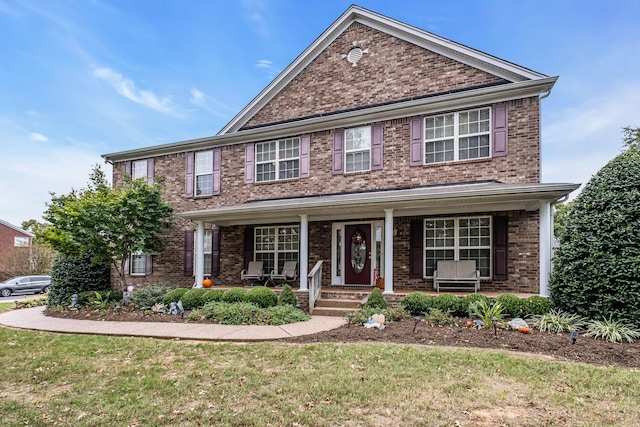 view of front of property featuring a porch and a front lawn