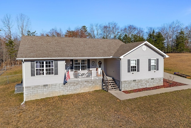 ranch-style home featuring covered porch and a front yard