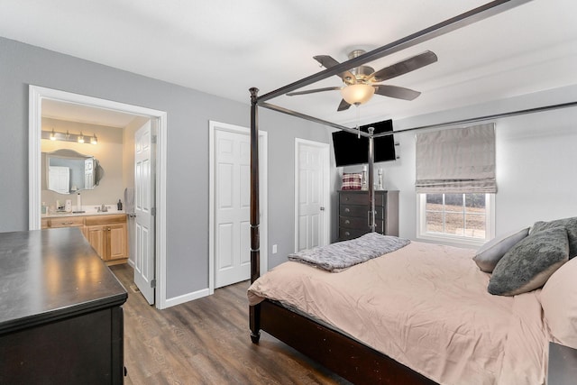 bedroom with dark hardwood / wood-style flooring, connected bathroom, sink, and ceiling fan