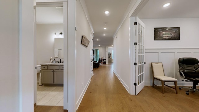 hall with french doors, sink, and light hardwood / wood-style flooring