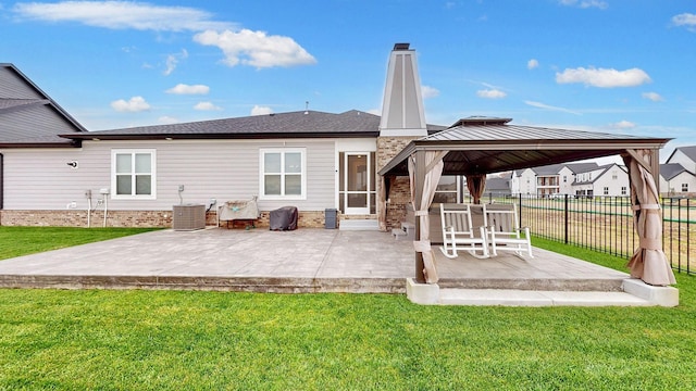 rear view of property with a gazebo, a lawn, and a patio