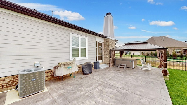 view of patio with a gazebo, a hot tub, and central AC unit