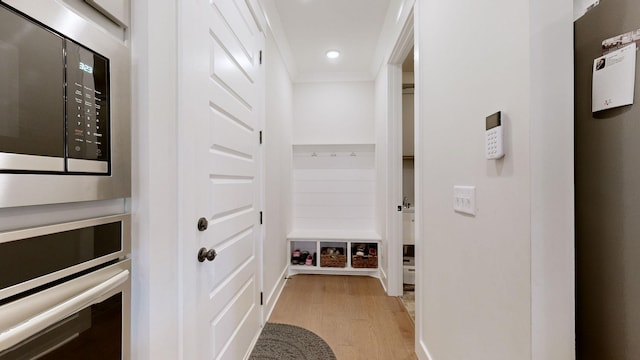 mudroom with ornamental molding and light hardwood / wood-style flooring