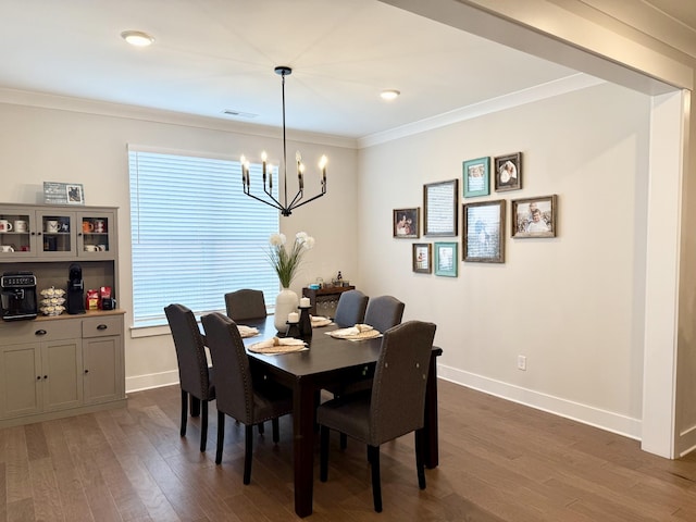 dining space with ornamental molding, dark hardwood / wood-style flooring, and a chandelier