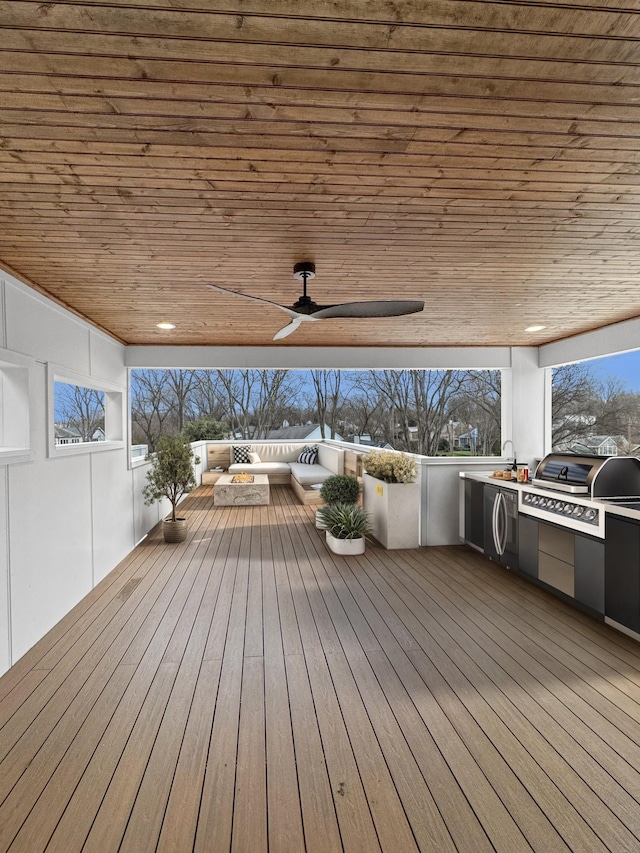 wooden deck with ceiling fan, a grill, sink, and area for grilling